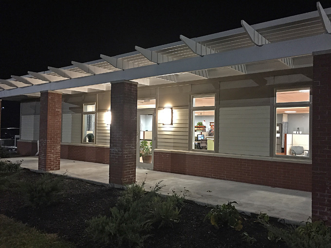 Color photo taken at night of side portico at New England Cancer Specialists, West Kennebunk, Maine.